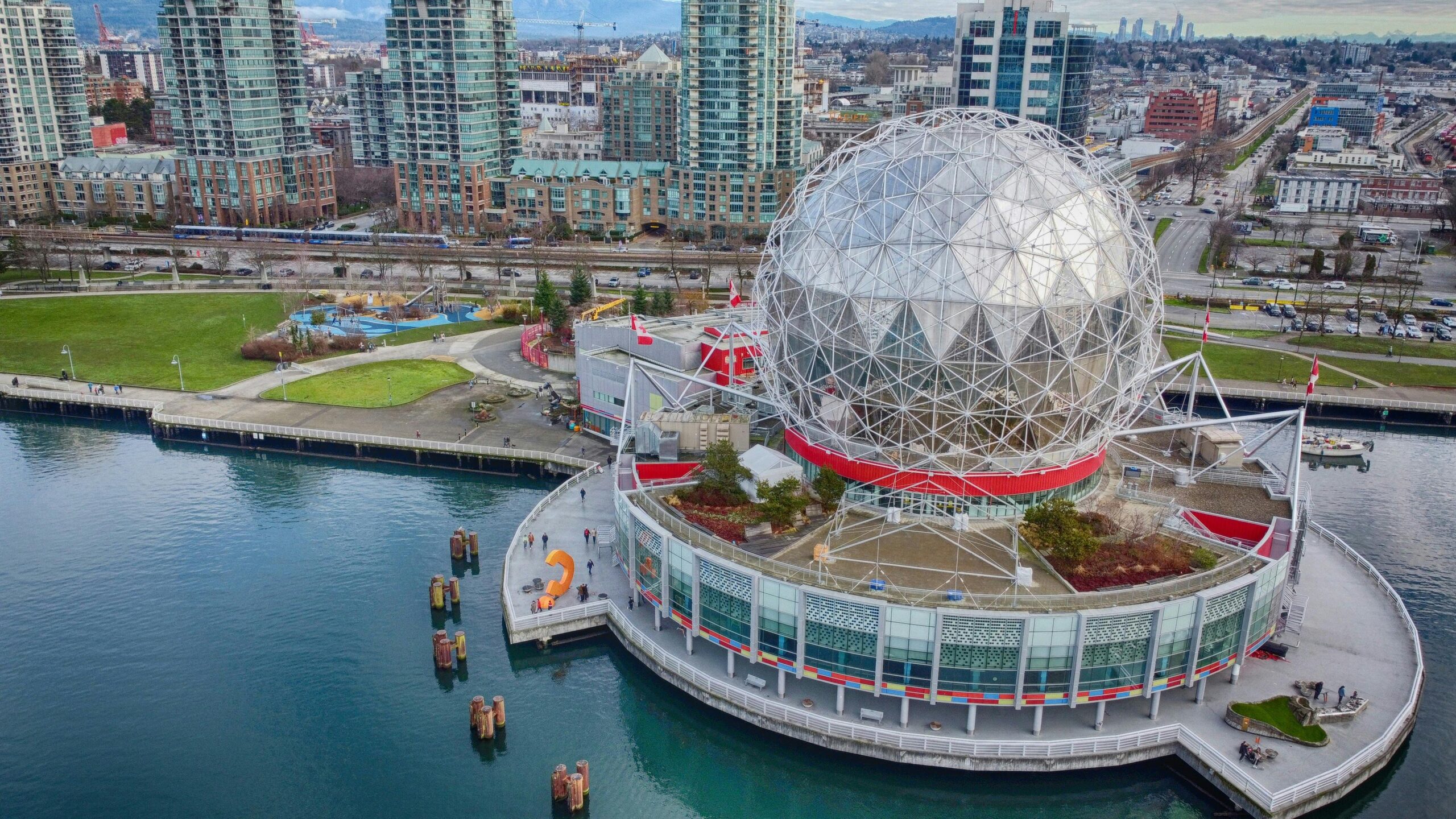 Aerial view of the TELUS World of Science in Vancouver, with surrounding high-rise buildings and waterfront