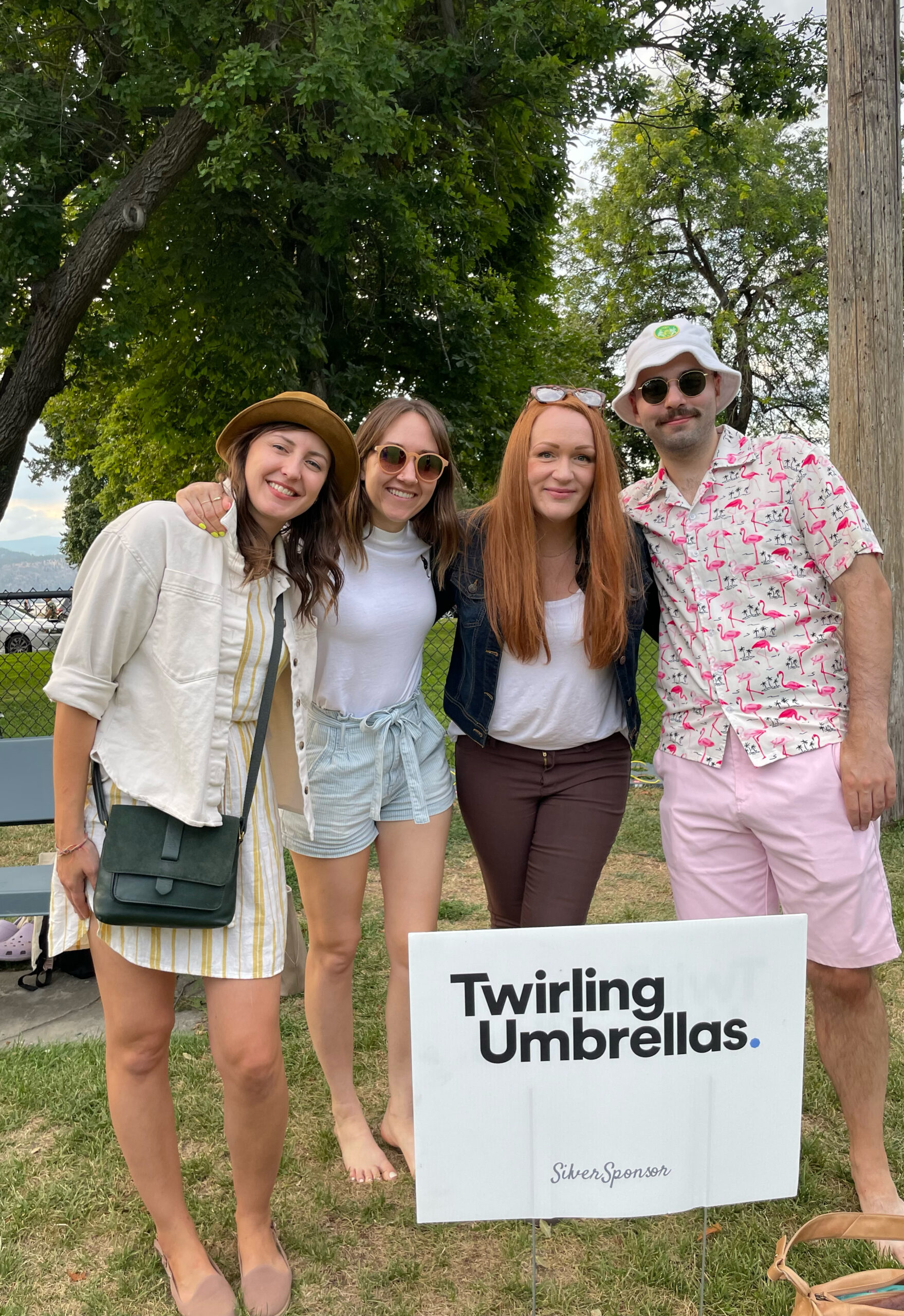 Team members of Twirling Umbrellas pose together outdoors, showcasing a close-knit and friendly team dynamic.